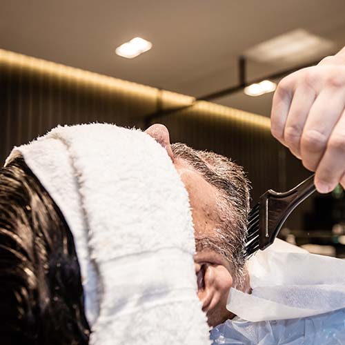 soins de la barbe au pinceau et serviette sur le visage